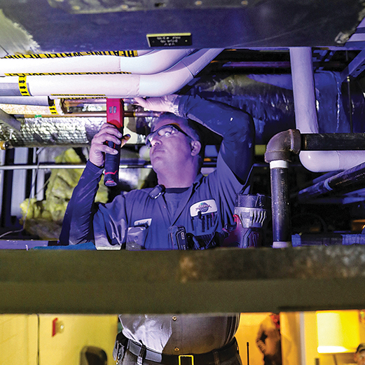 Facilities Team Member inspects piping for optimum operational performance