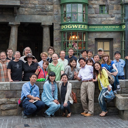 Group of Team members standing and kneeling in front of The Dogweed and Deathcap storefront in Hogsmeade at Universal Orlando Resort's The Wizarding World of Harry Potter