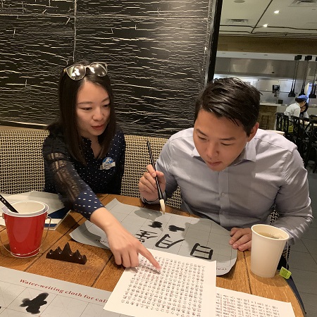 Two Team Members practicing Chinese calligraphy at Universal Orlando Resort’s Lunar New Year Celebration event.