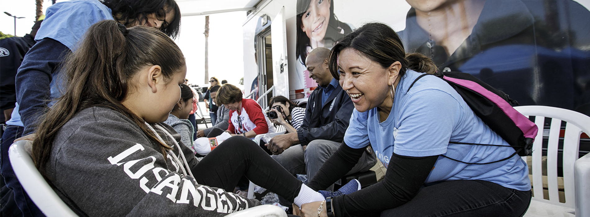 Universal Studios workers fitting shoes on kids.