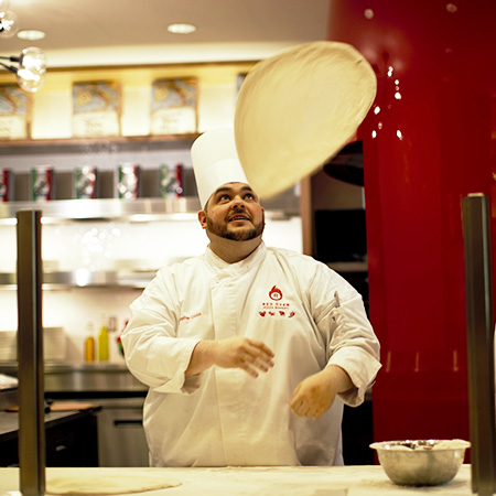 A gentleman making a pizza