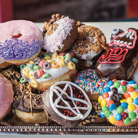 A platter covered in several donuts.