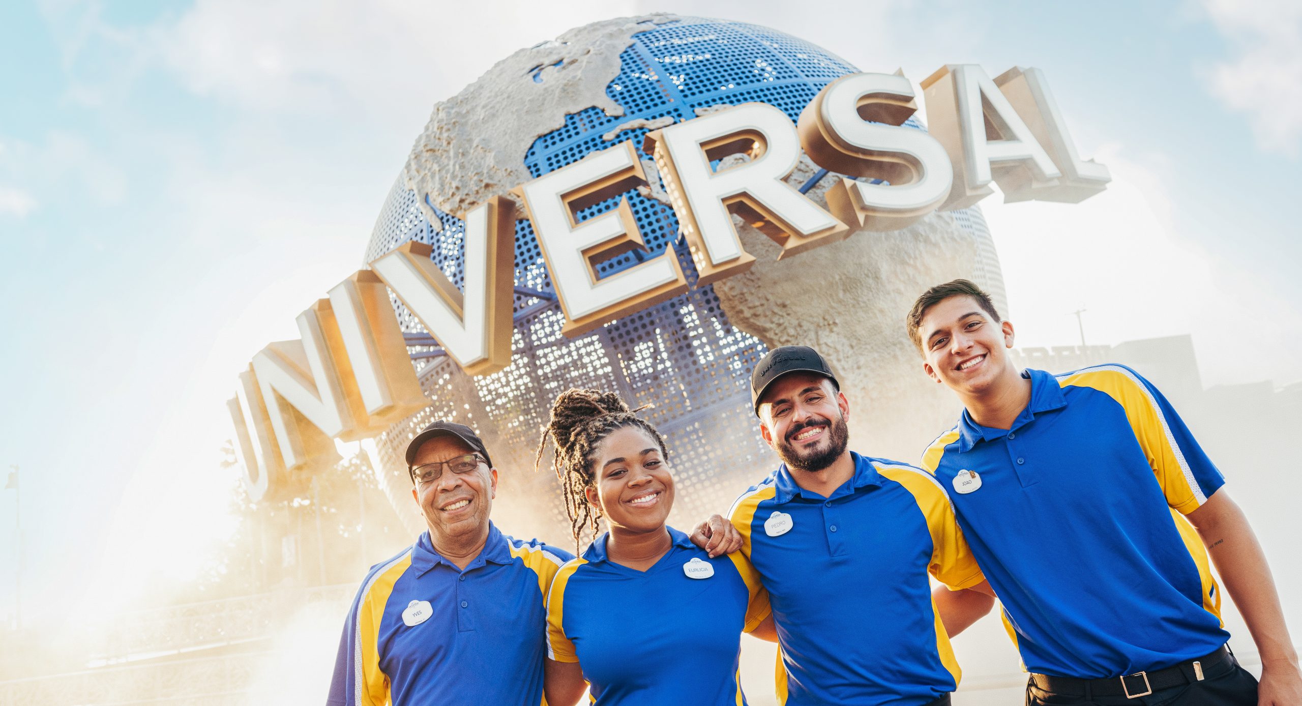TMs at Globe Group of four Team Members standing in front of the Universal Globe
